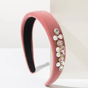 Close-up of pink velvet headband with baroque style pearls and rhinestone details