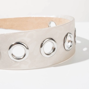 Close-up of champagne satin headband featuring silver metal eyelets and leather lining