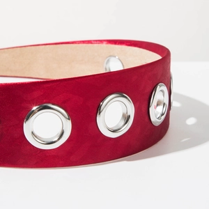 Macro view of dark red satin headband with silver metal eyelets and beige velvet lining