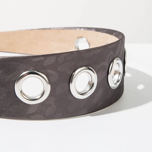Macro detail of dark leopard print headband with silver metal eyelet grommets