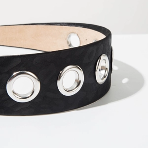 Detailed close-up of a wide black leopard textured belt featuring large silver metal eyelets