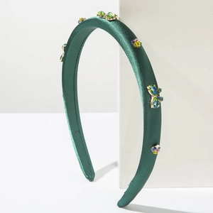 Serre-tête luxueux en satin vert foncé avec strass colorés et nœud sur piédestal blanc