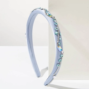 Dettaglio di un cerchietto in seta azzurra con strass e cristalli cuciti a mano di lusso