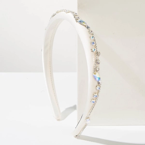 Dettaglio di cerchietto in raso bianco con strass iridescenti e cristalli fatti a mano