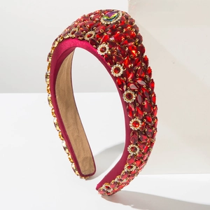 Close-up of red baroque padded headband with sparkling crystals and gold-edged rhinestones