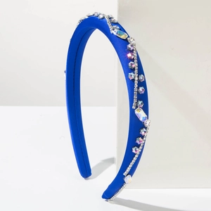 Dettaglio di un cerchietto in raso blu scuro con file intricate di strass sagomati