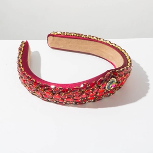 Close-up of luxury Baroque headband with red rhinestones and satin thick padding