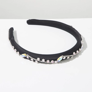 Dettaglio del cerchietto in velluto nero con strass scintillanti e motivi a onde in cristallo
