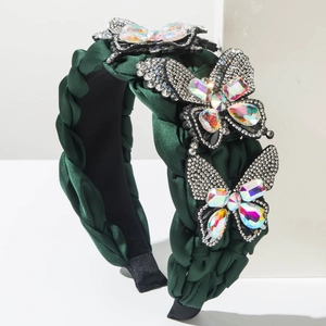 Detailed macro view of dark green woven headband with luxury crystal butterfly charms