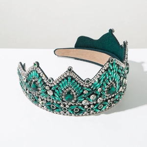 Detailed macro view of vintage emerald rhinestones and silver metal on baroque crown