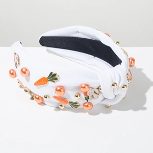 Détail d'un bandeau blanc noué avec breloques lapin carotte et perles orange