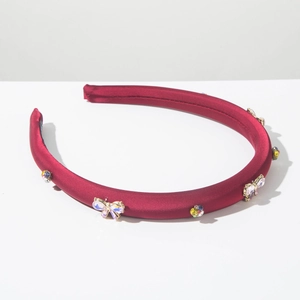 Détail d'un serre-tête en satin bordeaux avec strass colorés et motifs de papillons