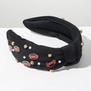 Detail eines schwarzen Knotenstirnbands mit Strasssteinen, Perlen und Rugby-Motiven