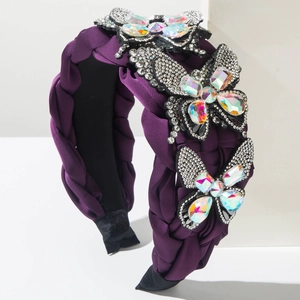 Close-up of purple braided headband with sparkling rhinestone butterflies on a white stand