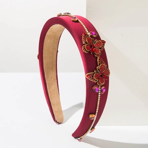 Detailed side view of velvet headband featuring red rhinestone butterflies and gems