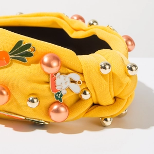 Détail de serre-tête tricoté jaune avec perles, rivets et charmant lapin mignon