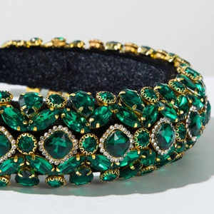 Détail du bandeau baroque avec pierres précieuses vertes sur velours noir luxueux