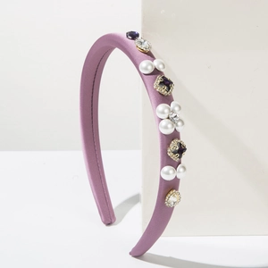 Detail of purple satin headband with embedded pearls, black gems and sparkling crystals