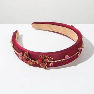 Macro detail of wine red padded headband featuring rhinestone butterflies and gemstones