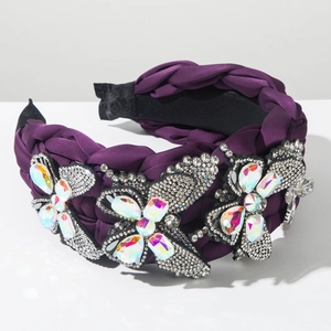 Detailed close-up of a wide purple braided headband with luxury crystal butterfly motifs