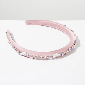 Dettaglio del cerchietto in raso rosa con strass ondulati e cristalli eleganti
