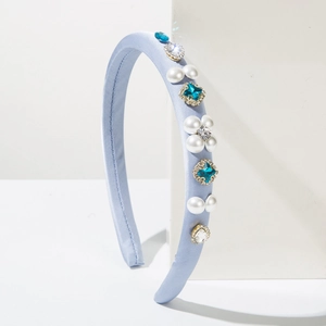 Detailed view of light blue satin headband with pearls and blue rhinestones