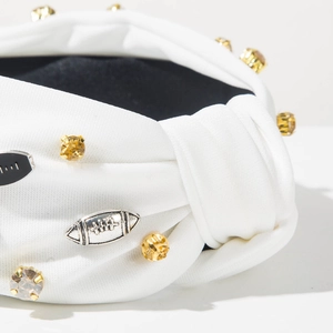 Nahaufnahme weißer geknoteter Haarreif mit Strass-Football-Anhängern und silbernen Details