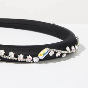 Dettaglio macro del cerchietto in raso nero con strass cangianti e cristalli lucidi