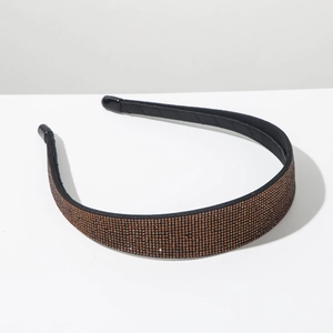 Close-up of champagne rhinestones on a wide black headband with soft fabric lining