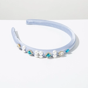 Detail showing white pearls and blue rhinestones on a light blue satin headband
