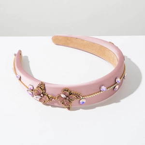 Close-up of pink satin headband with golden rhinestone butterflies and crystal trim