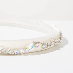 Dettaglio ravvicinato del cerchietto in raso bianco con cristalli AB e bordo di strass