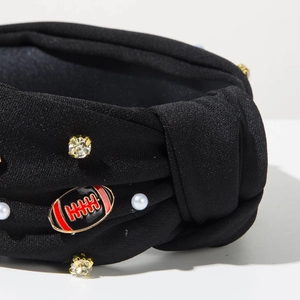 Detail eines schwarzen geknoteten Stirnbands mit Strasssteinen, Perlen und Football-Anhänger