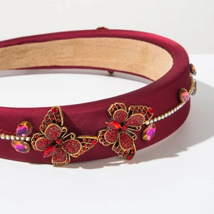 Detail view of burgundy satin headband with ruby butterfly crystal embellishments