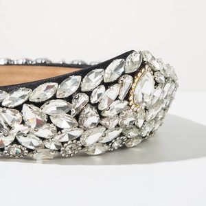 Close-up of luxury baroque headband with sparkling crystals on black satin fabric
