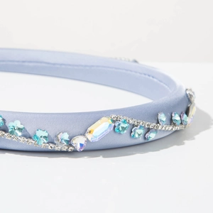 Dettaglio del cerchietto in raso azzurro con cristalli scintillanti e fiori di strass