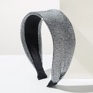 Macro detail of silver rhinestones on a thick padded headband with black ribbon ends