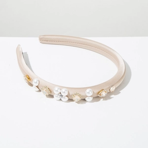 Close-up of champagne satin padded headband with pearl flowers and crystal accents