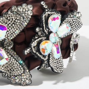 Macro detail of luxury brown silk scrunchie with crystal butterfly and floral gems