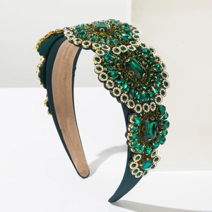 Detail of luxury emerald green baroque headband with sparkling crystals and gold accents