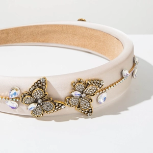 Detail of champagne satin headband with vintage gold crystal butterfly and dangling rhinestones