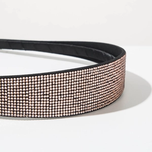Detail shot of multi-row pink rhinestones on a black velvet headband with elegant sparkle