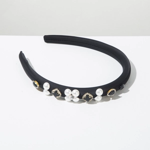 Detail of black fabric headband with white faux pearls and black floral rhinestones