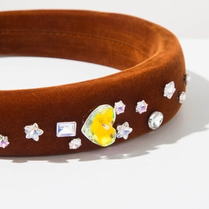 Détail d'un serre-tête vintage en velours marron orné de cristaux en forme de cœur