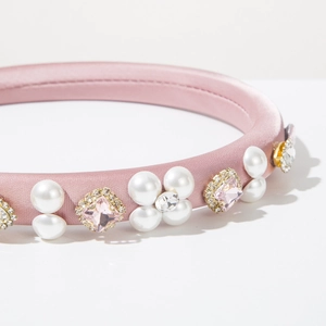 Detail of pink satin headband with white pearls and sparkling square rhinestones