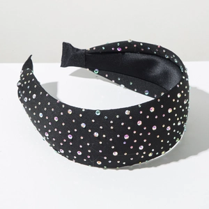 Detail of a wide black headband fully embellished with iridescent sparkling rhinestones