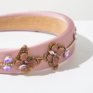Macro detail of luxury butterfly headband with pink rhinestones and purple satin