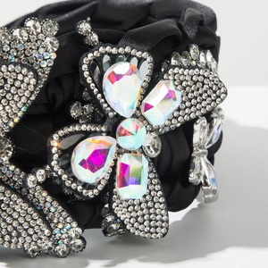 Macro detail of luxury black satin headband featuring hand-woven crystals and butterfly