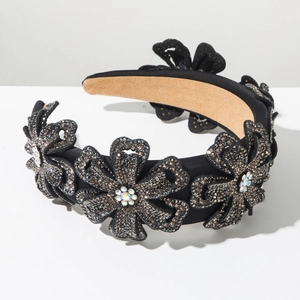 Detailed close-up of vintage black wide headband with sparkling crystal five-flower design