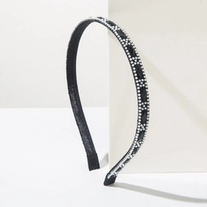 Detail of elegant black headband with white pearls and black diamond-cut gemstones